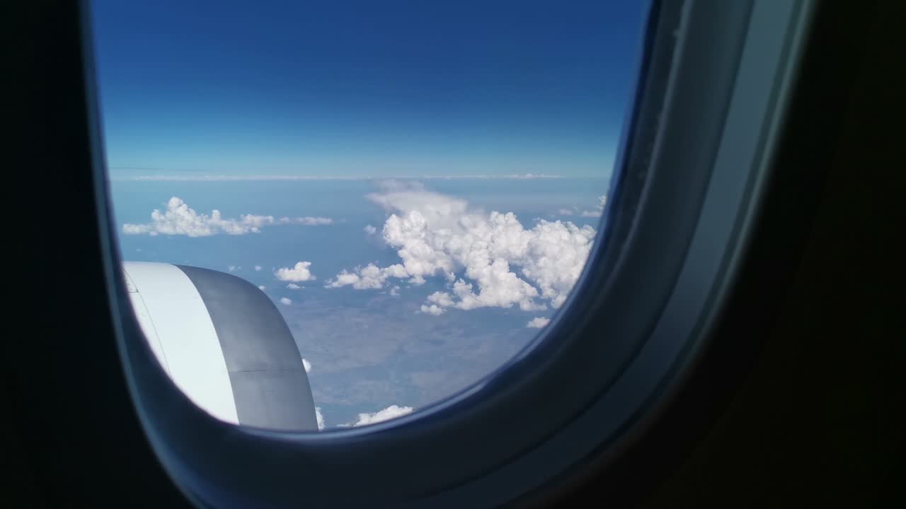 이코노미 클래스 창을 통해 비행기 엔진과 하늘의 적운 구름에 대한 조감도