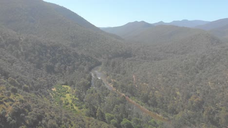 Toma-Aérea-Que-Avanza-Y-Revela-Un-Río-Alto-Que-Fluye-A-Través-De-La-Selva-Australiana