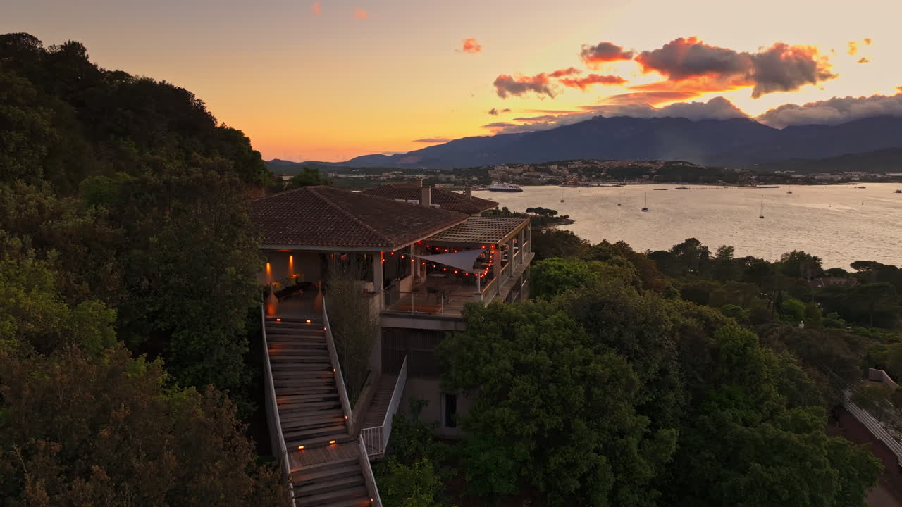 Aerial drone shot over the coastline of Porto Vecchio, southern Corsica, France. Golden hour sunset, warm colorful sky