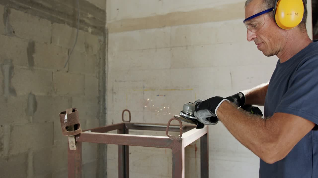 hombre usando un molinillo de metal en un objeto de metal con chispas volando en cámara lenta