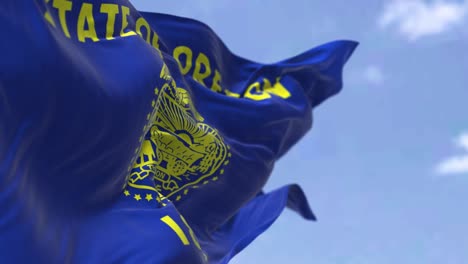 la bandera del estado de oregón ondeando en el viento.