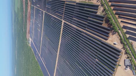 vertical drone shot of large solar panel farm in scenic landscape of dominican republic during sunny day