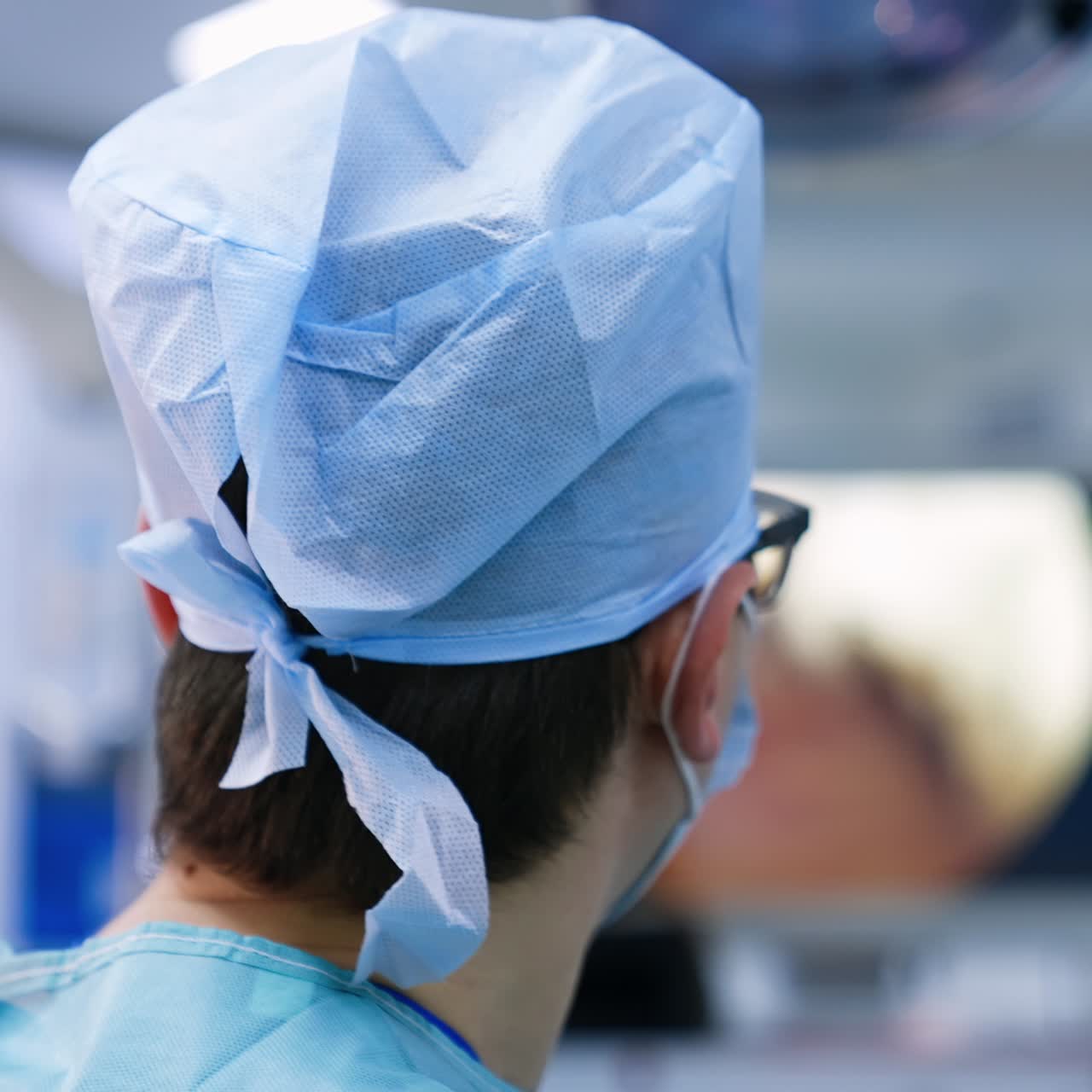 Surgeon looks at the monitor at work of medical instrument. Doctors perform operation at leg