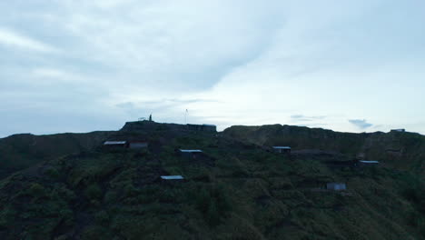 Close-up-aerial-shot-of-scattered-residential-houses-and-farms-at-the-top-of-the-mountain-peak-of-Mount-Batur-in-Bali,-Indonesia