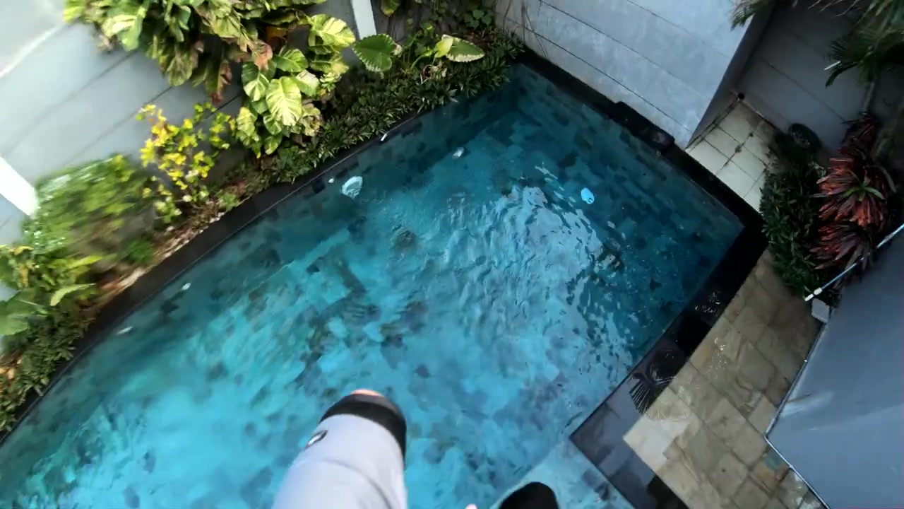 POV-optagelse af en mand, der hopper ned fra taget af sit hus og ned i en swimmingpool nedenfor