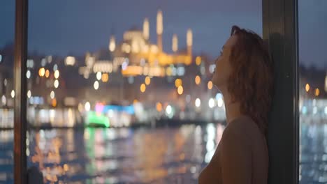 woman looking at istanbul at night from a boat