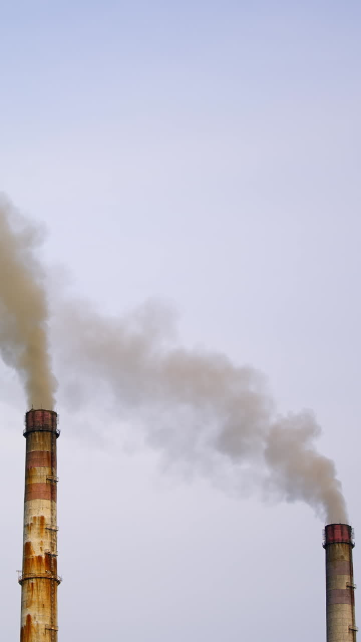 Industrial chimneys with gas and smoke. Towers with vapor from metallurgical industrial factory. Poisoned air. Pollution of nature. Toxic substances. Vertical video