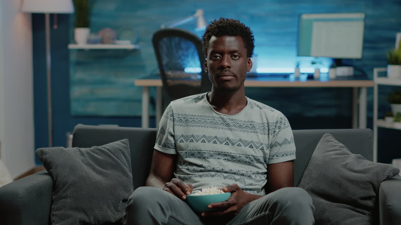 POV of black person watching movie on television at home