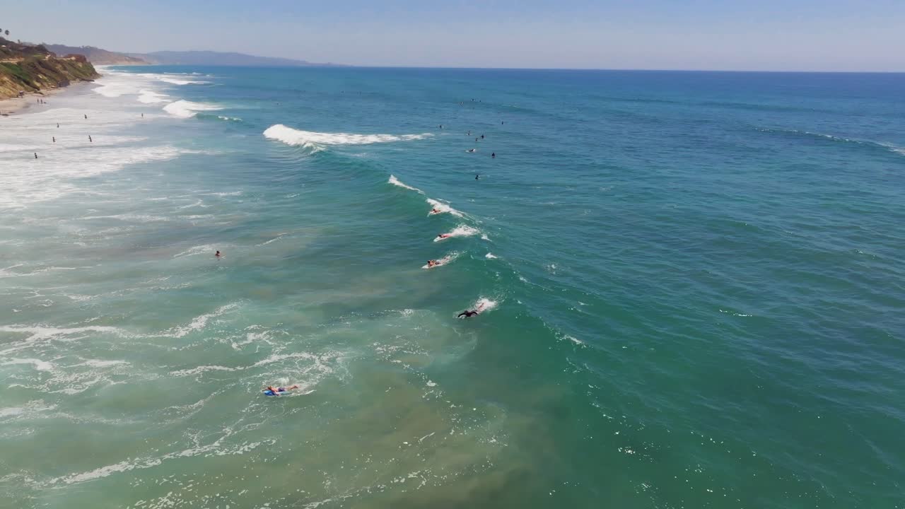 Surfisti che Cavalcano le Onde sulla Spiaggia di Del Mar a San Diego, California - Ripresa Aerea con Drone