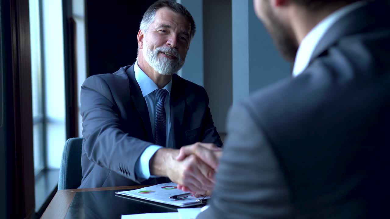 socios comerciales se reúnen en el vestíbulo del edificio de oficinas y se saludan con un apretón de manos