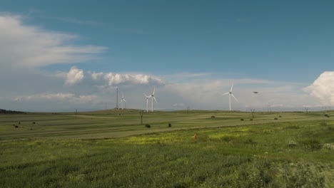 wind generator farm in green fields in gori below blue skies, georgia