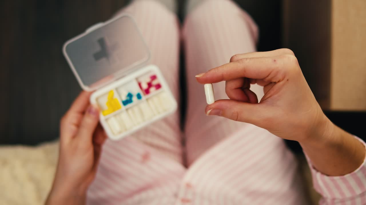 침대에서 약을 복용하는 여성