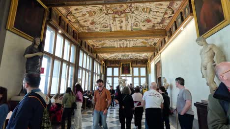 turistas explorando las exposiciones de arte de la galería uffizi