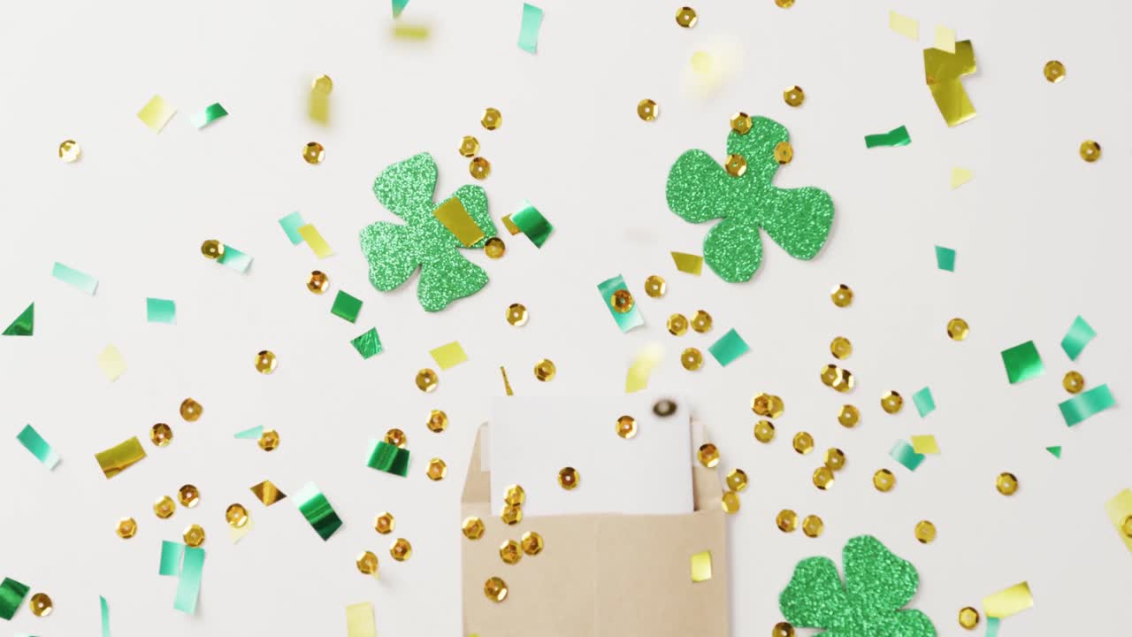 Video of st patrick's green shamrock, letter and sequins on white background