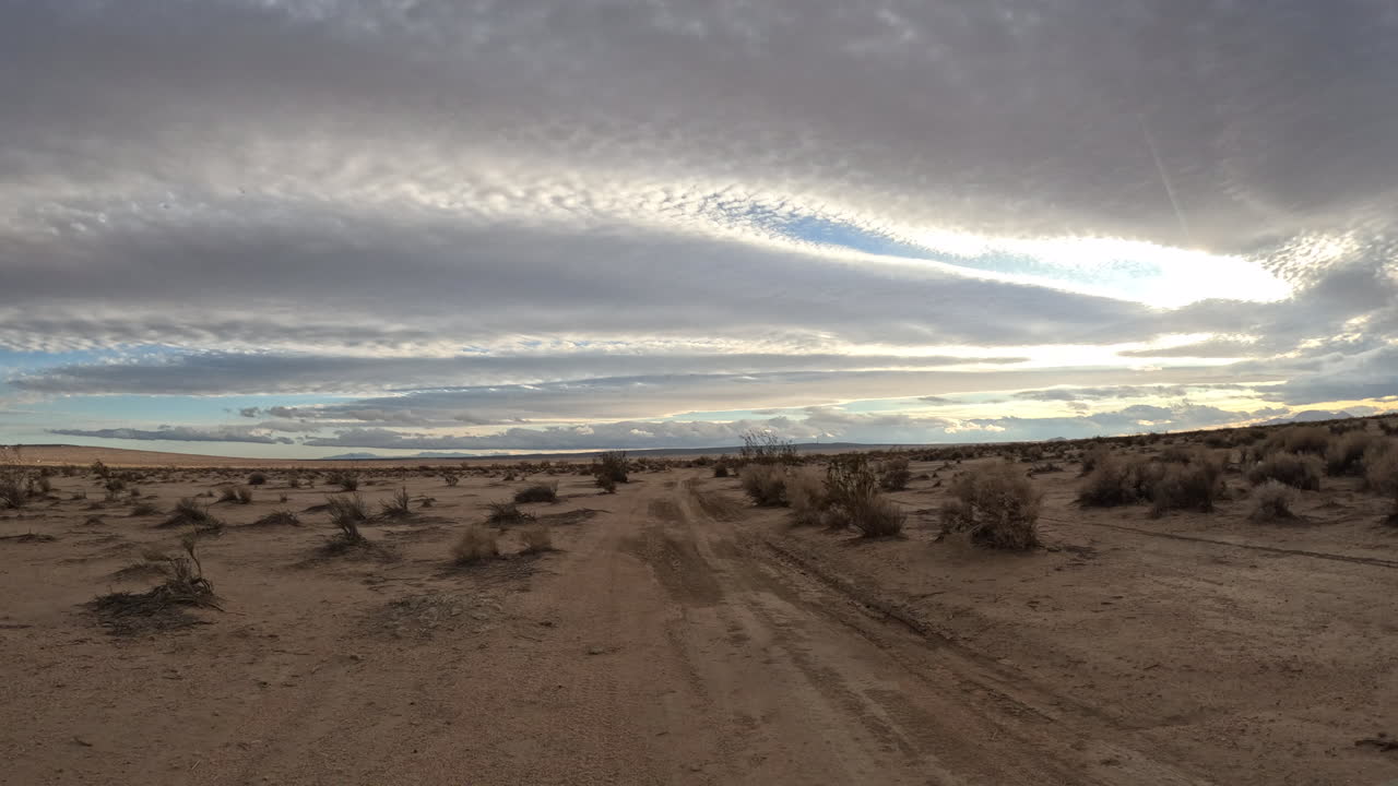 vista en primera persona de una persona que conduce una motocicleta a lo largo de un sendero todoterreno en el desierto de mojave - hiperlapso pov