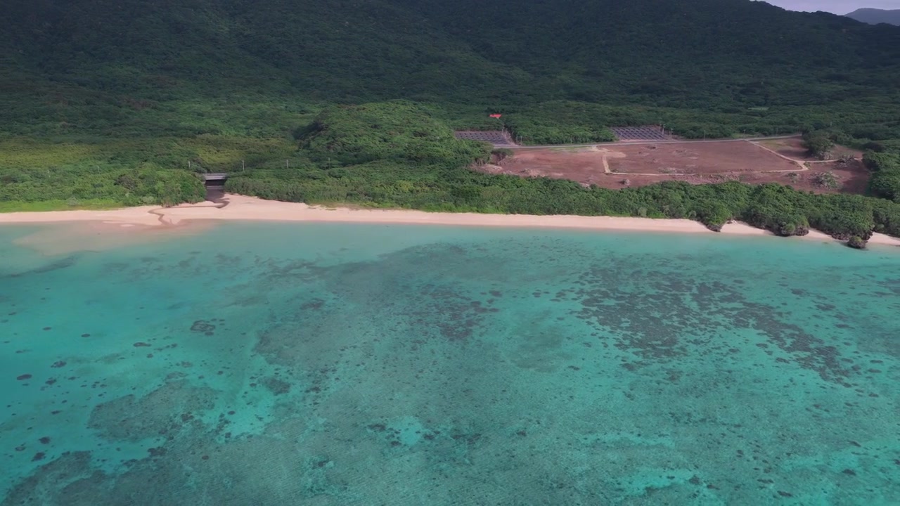Filmato aereo orizzontale con panoramica a destra sopra le sabbie bianche e le acque turchesi di Nosokoniaru Beach e Ibaruma Bay, Isola di Ishigaki, Okinawa, Giappone
