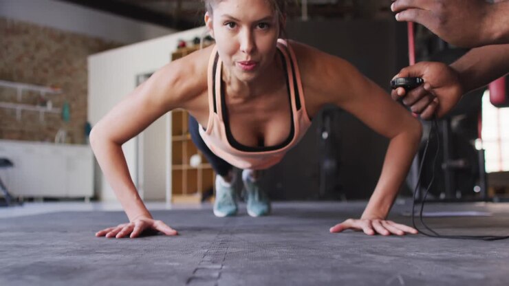 Video of african american male trainer motivating caucasian woman for doing push ups
