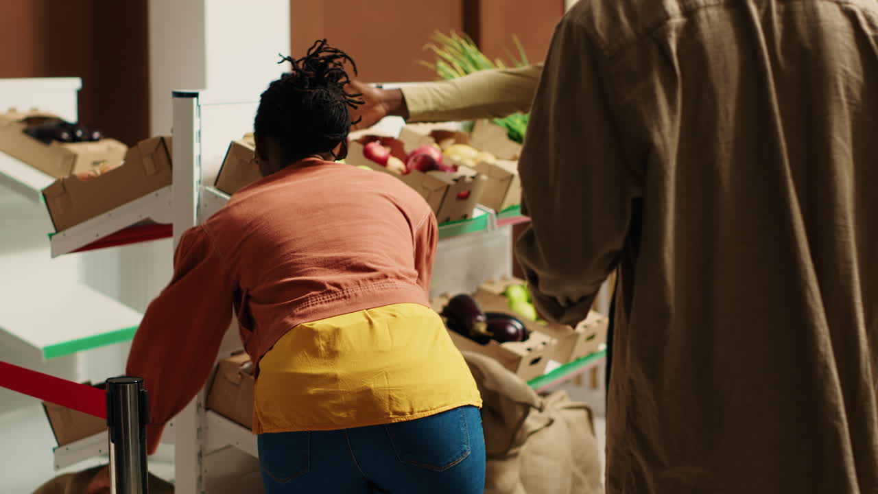 commerciante locale che apre le porte del negozio di alimentari e dà il benvenuto ai clienti