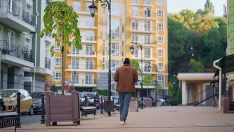 Lässiger-Mann-Zu-Fuß-Durch-Die-Stadt,-Modernes-Wohngebiet,-Rückansicht.-Konzept-Des-Einsamen-Wanderers