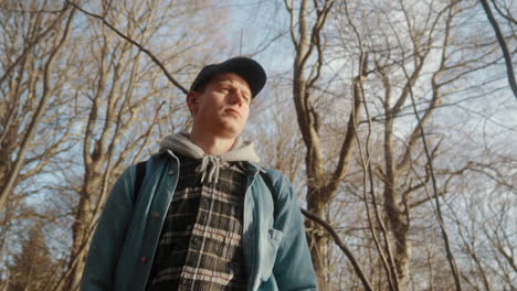 young man walking in the sunny forest woods