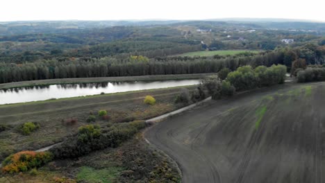 Aerial-shot-of-meadow-and-lake-in-Kolbudy,-pomeranian-district-in-Poland