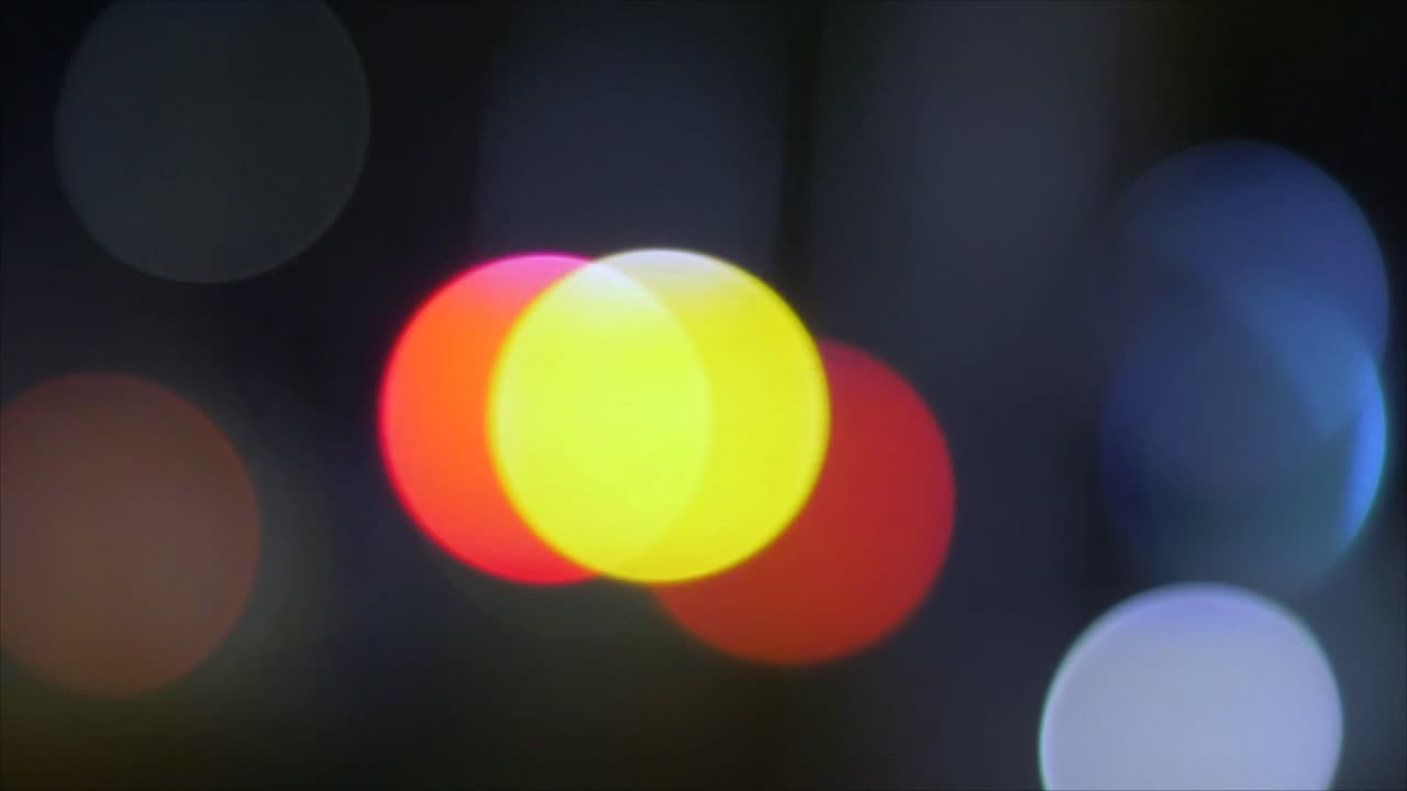 Fargerike bokeh-sirkler som skifter og beveger seg om natten