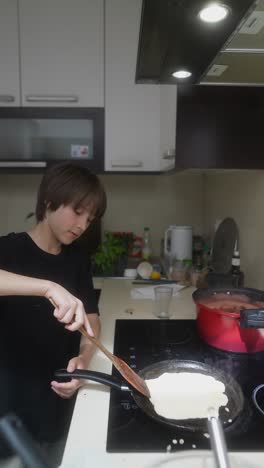 child cooking pancakes in a kitchen