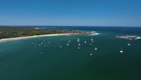 Aerial-view-of-moored-boats-on-the-coast-of-Flamingo-Guanacaste,-sunny-day-in-Costa-Rica