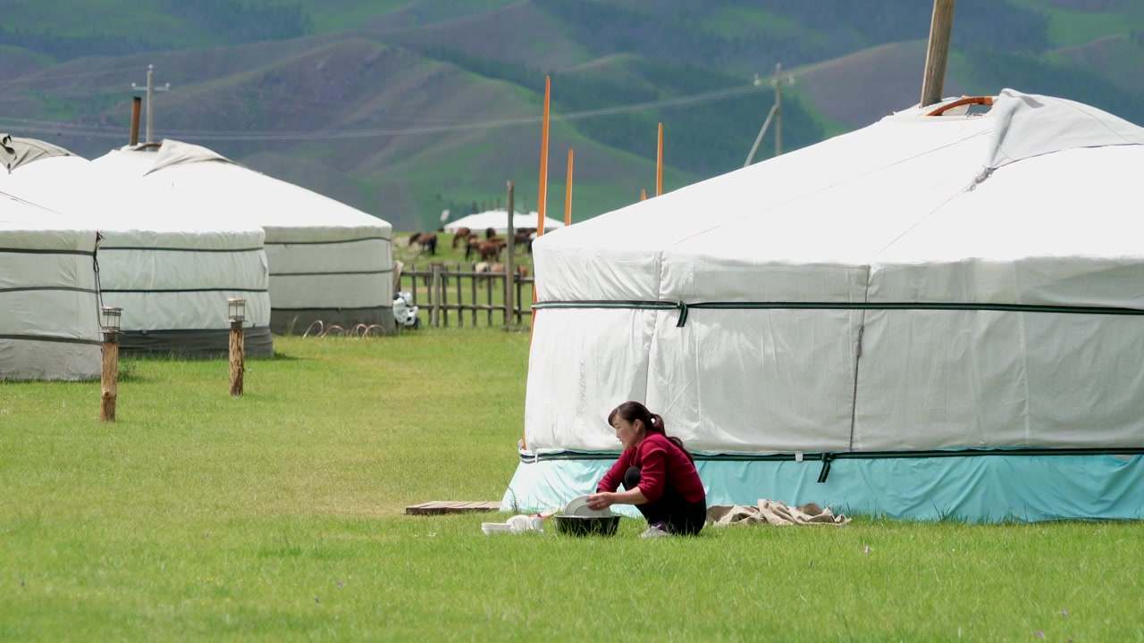 Mongolisk kvinna förbereder mat utanför en traditionell jurta