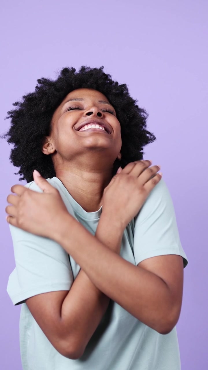 Donna afroamericana gioiosa che ride e si abbraccia.