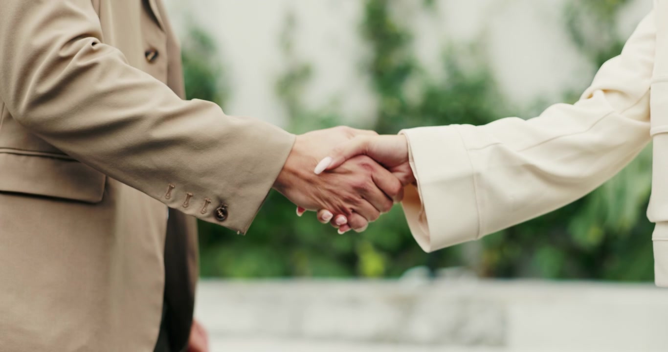 นักธุรกิจกำลังจับมือกันในบรรยากาศกลางแจ้ง