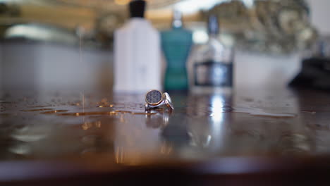 a close up view of a ring on the dressing table where as some water drops are dropping into it