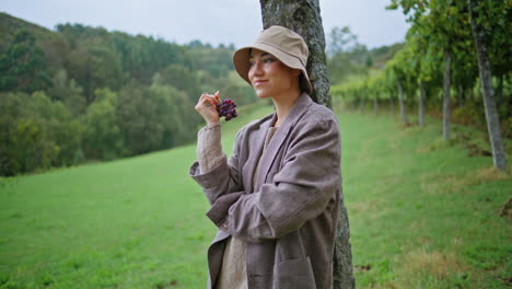 woman enjoying grapes in a vineyard