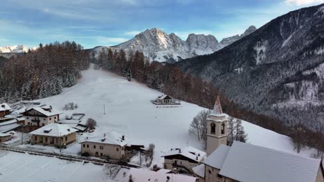 vista aérea de drones de un pequeño pueblo en la montaña con nieve en invierno