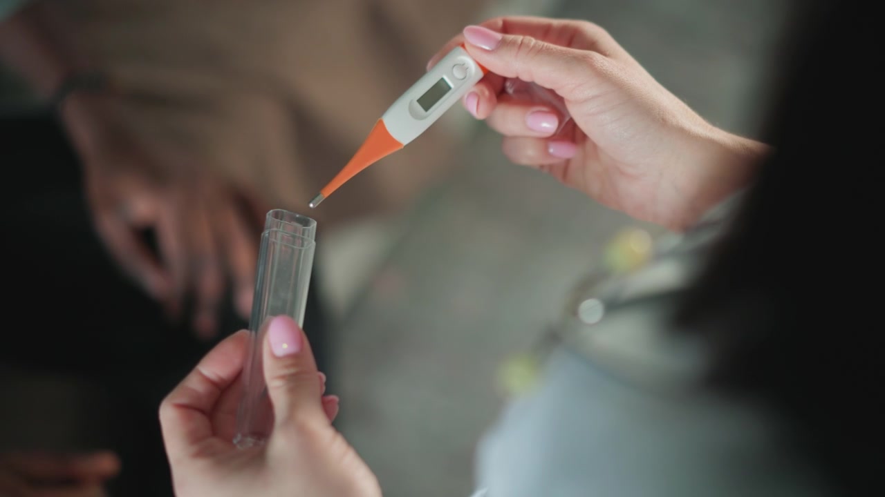 Il medico visita il bambino. Il pediatra dimostra la misurazione della temperatura. Un professionista medico mostra il termometro al genitore. Consulto sulla salute del bambino con dimostrazione del termometro in un ambiente familiare.