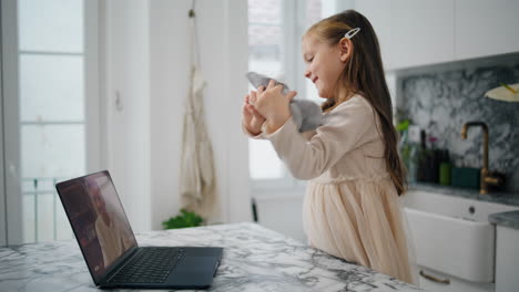 Niedliches-Baby-Zeigt-Spielzeug-Auf-Dem-Laptop-Bildschirm,-Gemütliches-Zuhause,-Nahaufnahme.-Positives-Mädchen-Spricht