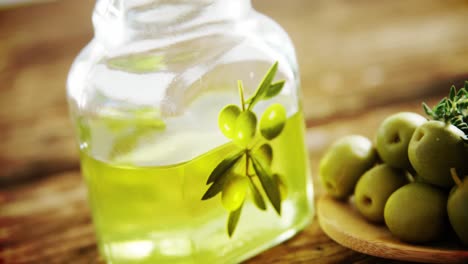 Olive-oil-jar-and-green-olives