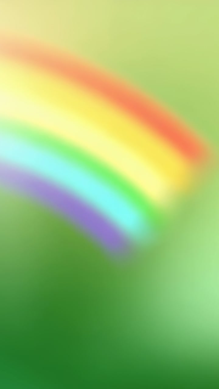 Video vertical: Arco iris ascendente que barre en diagonal sobre un fondo verde, aportando color difuminado.