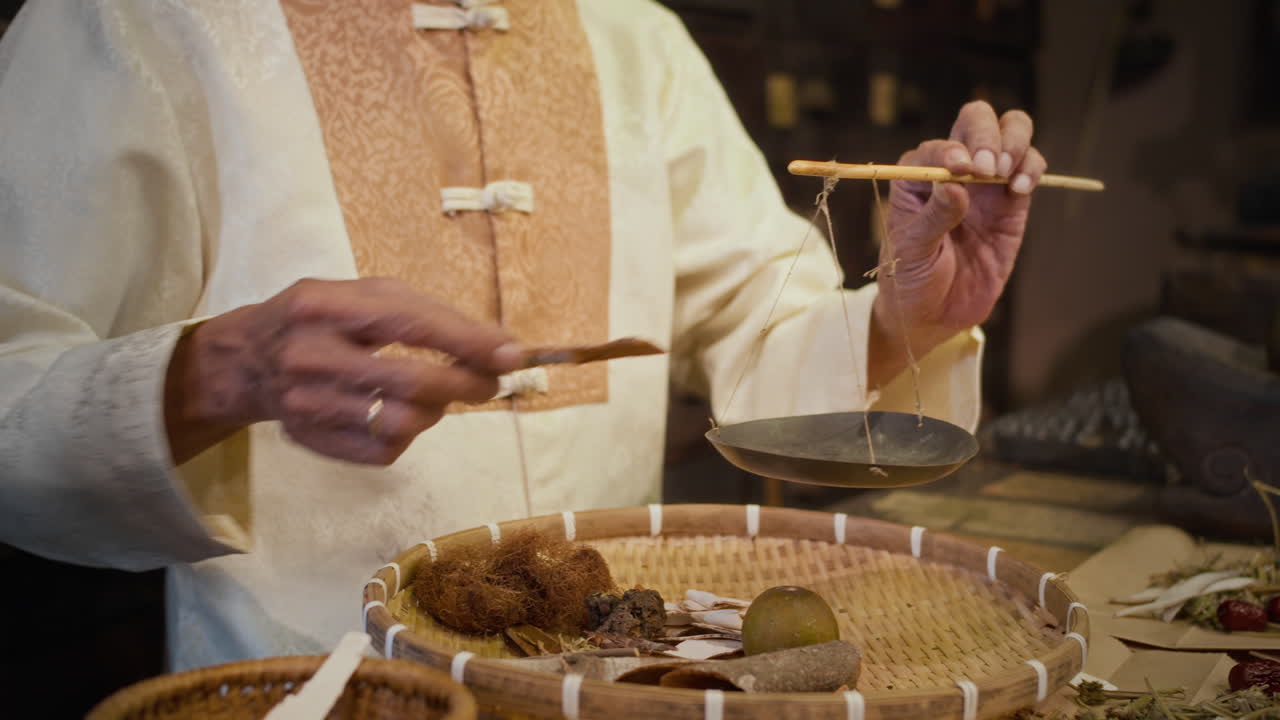 Unrecognizable Traditional Medicine Practitioner Putting Dried Herbs on Scales