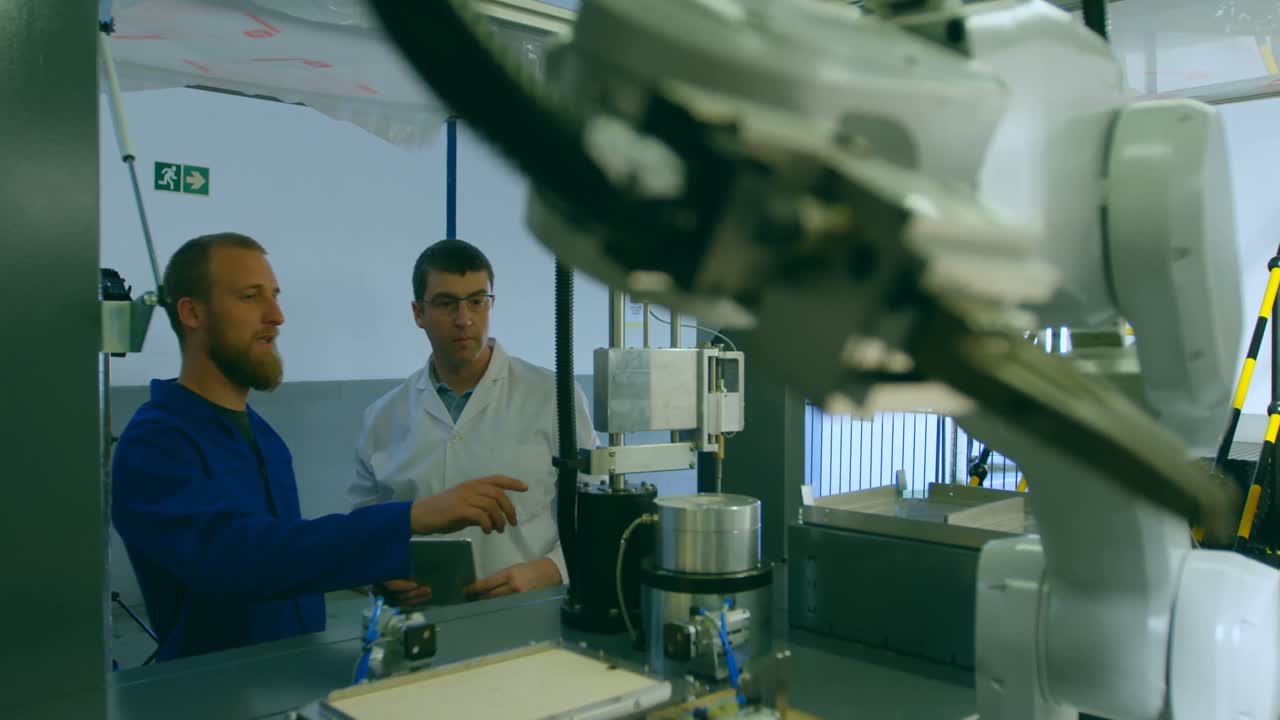 ingenieros robóticos masculinos trabajando en el almacén 4k