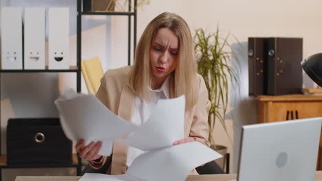 stressed businesswoman work at unpaid bank debt doing paperwork planning budget throws paper bills