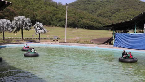 people enjoying bumper boats on a sunny day