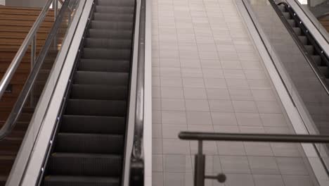 escalator in empty shopping center mall wide panning shot