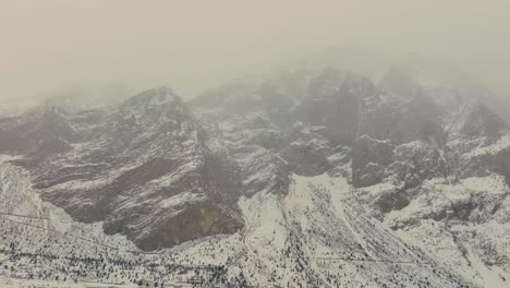 Toma-Panorámica-Con-Drones-De-Una-Montaña-Cubierta-De-Nieve-En-El-Norte-De-Pakistán,-Valle-De-Naltar,-Invierno-De-Gilgit