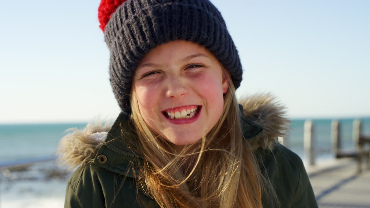 Ansikt, jente og barn på strand med lue
