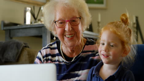 grandmother and granddaughter using digital tablet in living room 4k