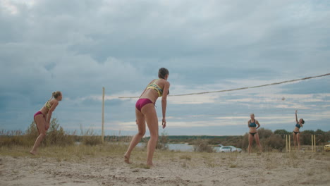 sportswomen are playing volleyball on beach court at summer training of professional female teams active and sporty lifestyle