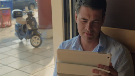 Man-working-with-tablet-PC-in-cafe