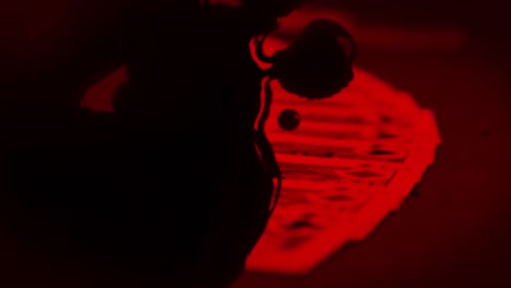 cartas de juego con luz roja y gotas negras sobre fondo negro