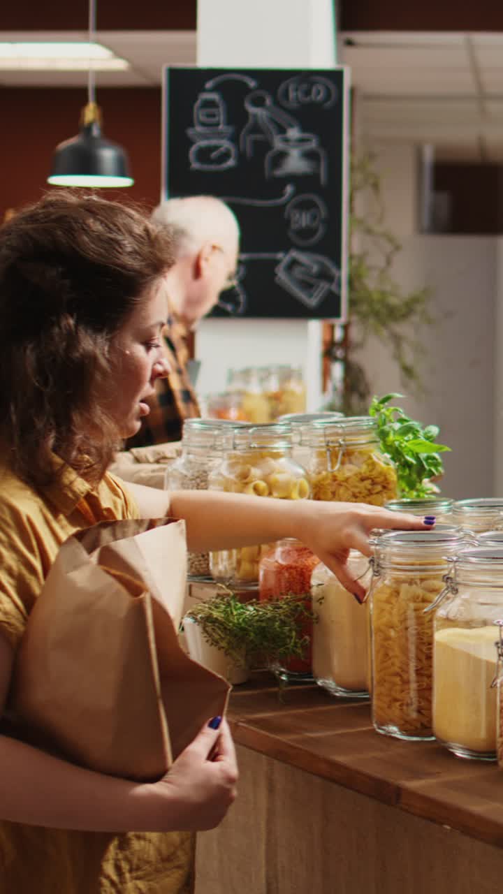 Vídeo vertical: un cliente de una tienda de alimentos ecológicos habla con un vendedor